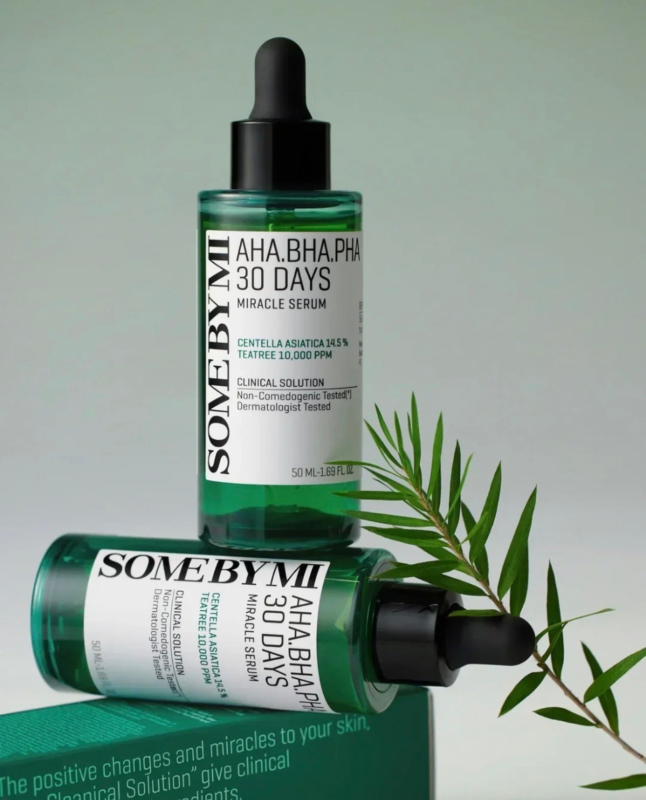 Two bottles of Some By Mi AHA.BHA.PHA 30 Days Miracle Serum with a green leaf on a light gray background.